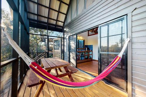 a hammock on a balcony of a house at Toucan Cabaña at Inn The Trees -Gold Standard Certified in Seine Bight Village