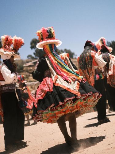 Eine Gruppe von Menschen in Kostümen spaziert an einem Strand in der Unterkunft Titilaka by Andean in Tililaca