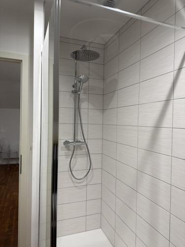 a shower with a shower head in a bathroom at Le Trente 9 in Neufchâteau
