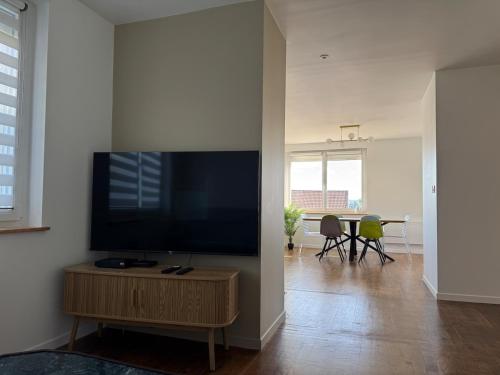 a living room with a flat screen tv on a wall at Le Trente 9 in Neufchâteau