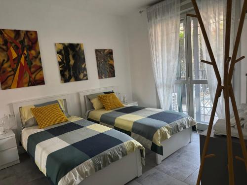 a bedroom with two beds and a window at Maison Du Pic - Rho Fiera in Pero