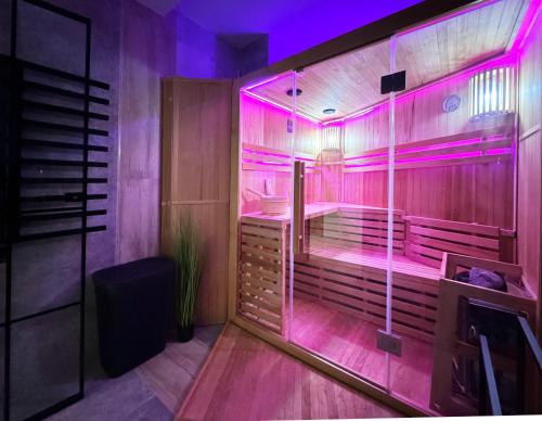Un baño con sauna con luces violetas. en Heaven Sauna Residence, en Rzeszów