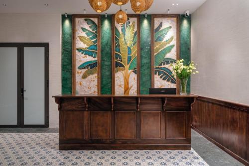 a lobby with a reception desk with a painting on the wall at The Greenary Garden in Ninh Binh