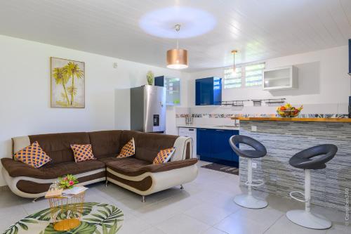 un salon avec un canapé et une cuisine dans l'établissement Kayna, à Sainte-Luce