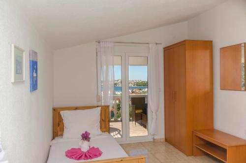 a bedroom with a bed with a pink dress on it at Apartments Nedi in Podglavica