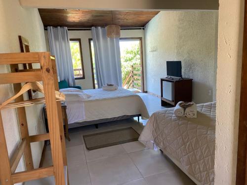 a bedroom with two beds and a window at Pousada Casa Campeche - Floripa in Florianópolis