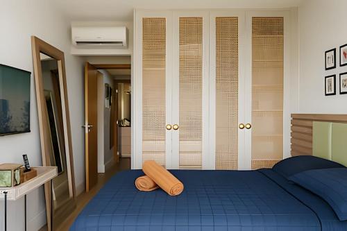 Schlafzimmer mit einem blauen Bett und einem Kopfteil aus Holz in der Unterkunft Flat de luxo no Monte Castelo - by Haus in Bezerros