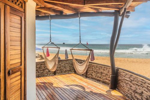 a porch with a view of the beach with hammocks at Il Gatto Rosso in San Agustinillo