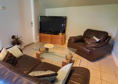 a living room with two couches and a flat screen tv at Gite 3 étoiles Escapade à la campagne in Xertigny