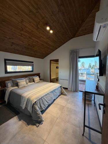 a bedroom with a bed and a desk and a window at Agua de Tajamar in Alta Gracia