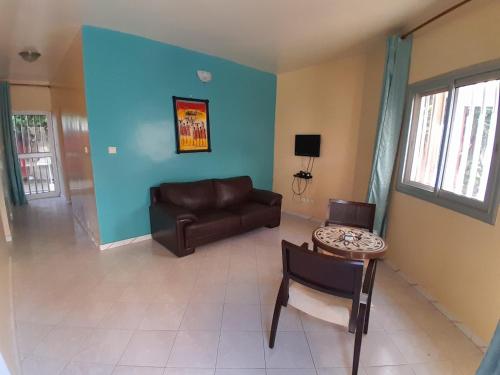 a living room with a couch and a table at Le Noflaye in Sali Nianiaral