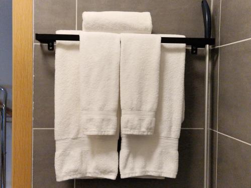 un grupo de toallas blancas en un toallero en el baño en Guesthouse Mikael, en Höfn