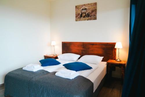 a bedroom with a large bed with blue pillows at Hotel Hafnarfjall in Borgarnes