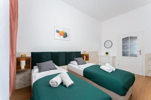 two beds in a room with green and white at Wonderful Apartments in the Center of Krakow in Kraków