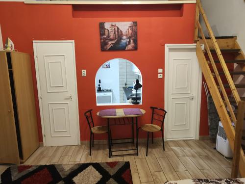 a dining room with orange walls and a table and chairs at Erik Apartments in Budapest