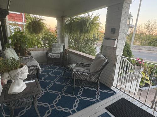 a porch with two chairs and a table and chairs at Classic Colonial House facing Niagara Falls in Niagara Falls