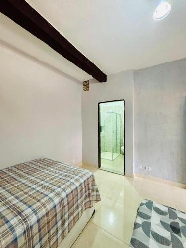 a bedroom with a bed and a large window at Chalés em Ilhabela 01 in Ilhabela