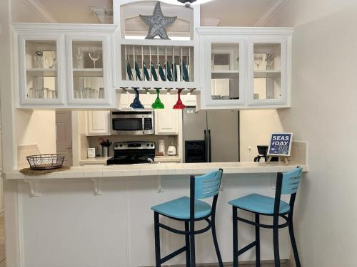 eine Küche mit zwei blauen Stühlen an der Theke in der Unterkunft Family Friendly Beach Condo with Pool in South Padre Island