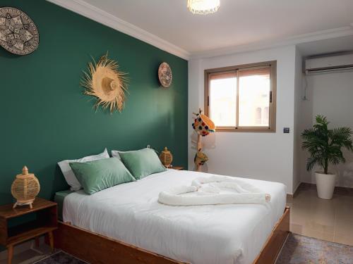 um quarto com uma cama grande com uma parede verde em Fib Houses em Ouarzazate