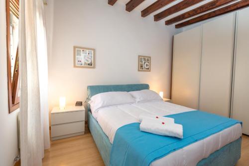 1 dormitorio con 1 cama azul en una habitación blanca en Venice Appartament Salini - Near the Biennale, en Venecia
