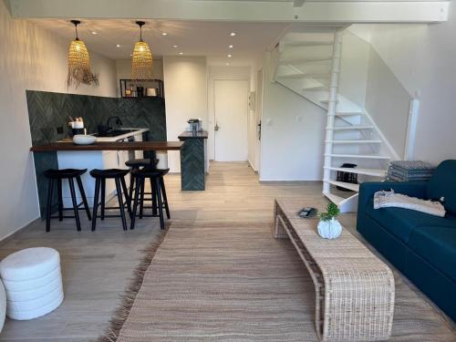 a living room with a blue couch and a kitchen at Mare Gaillard in Mare Gaillard
