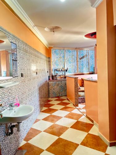 uma casa de banho com lavatório e piso em xadrez em Surf Taliouin Appartment Taghazout em Taghazout