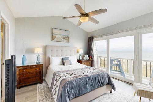 a bedroom with a bed and a ceiling fan at Oceanfront Townhouse in Carolina Beach