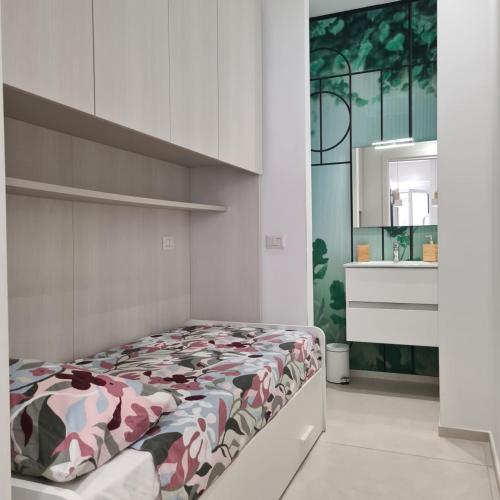 a bedroom with a bed with a floral comforter at RESIDENZA CORSO DALMAZIA in Civitanova Marche