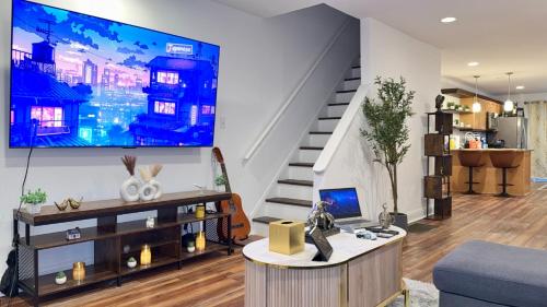 a living room with a large tv on the wall at Spacious Private Ensuite, With Private Bath, Outdoor Space, Workstation, Gym, & All Utilities Included in Point Breeze Home in Philadelphia