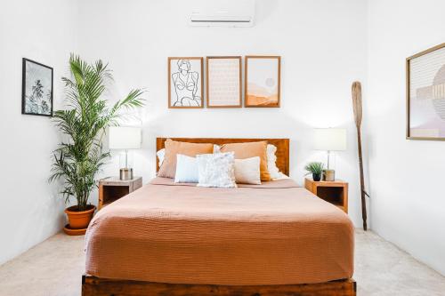 a bedroom with a large bed with two plants at Downtown Casa Conchita Guest Suites in Sayulita
