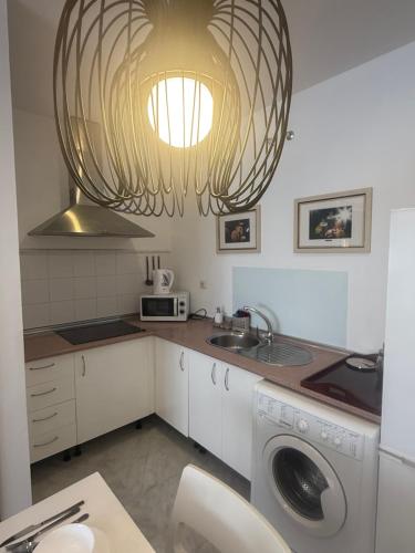 a kitchen with a washing machine and a chandelier at ModernLux in Bormujos