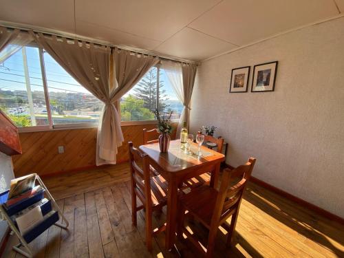 a dining room with a table and a large window at Hostal Boutique F in El Quisco