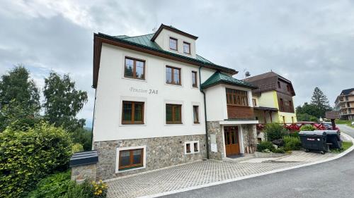 扬斯凯拉兹涅Penzion Jas的街道上白色的建筑,有绿色的屋顶