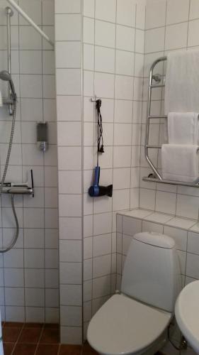 a bathroom with a toilet and a shower with towels at Lilla Hotellet in Lund