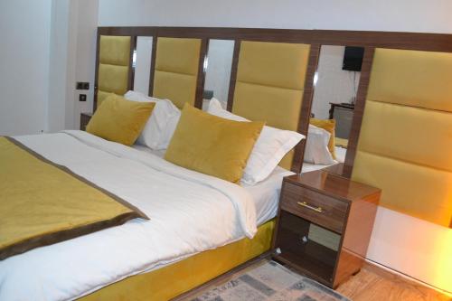 a bedroom with a large bed with a wooden headboard at Hôtel Sable d'Or in Tan-Tan
