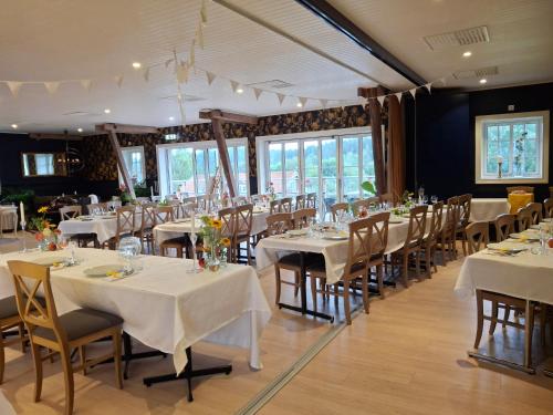 a dining room with white tables and chairs at Älgbergets Bed & Breakfast in Ucklum