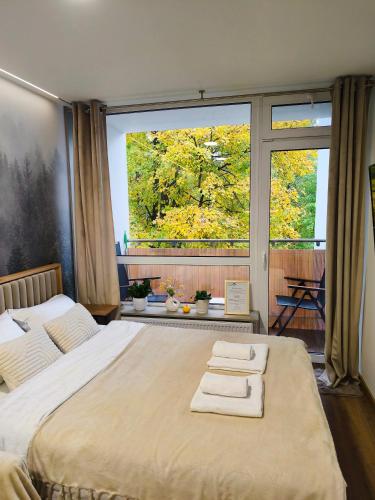 a bedroom with a large bed with two towels on it at Apartament Ustroń 20 in Ustroń