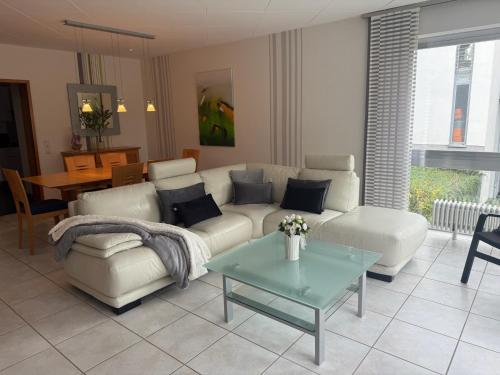 a living room with a white couch and a table at 130 qm Apartment mit Garten und Stellplatz in Riegelsberg