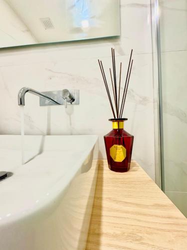 a vase with sticks in it sitting next to a sink at Douro Views by MyMoradia in Porto