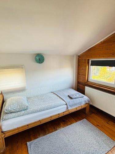 a bedroom with a bed and a clock on the wall at Pokoje Slawin in Lublin