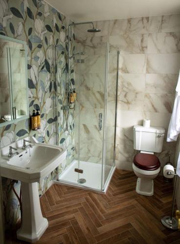 a bathroom with a shower and a toilet and a sink at Hill House Cashel in Cashel