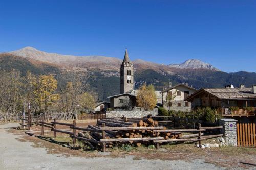 a village with a church and a fence and a church at Maison Dolce Vento - Happy Rentals in Oulx