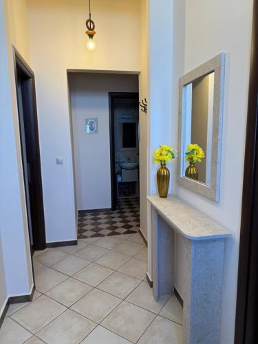 a hallway with a counter with yellow flowers in a vase at THALASSA Seafront in Vrontados