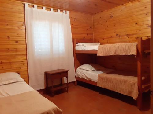 a bedroom with two bunk beds and a window at Pacha Quilla in El Mollar