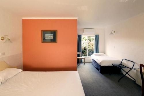 a room with two beds and a window at Hepburn Springs Motor Inn in Hepburn Springs