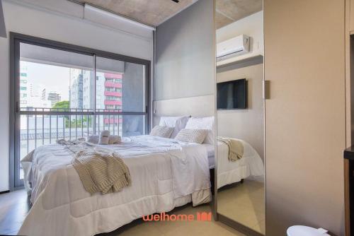 a bedroom with a bed and a large glass window at Studio na Vila Mariana proximo a Unifesp e Estacao in Sao Paulo