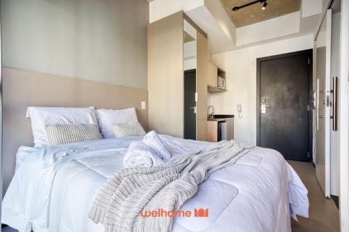a bedroom with a white bed with a blanket on it at Studio na Vila Mariana proximo a Unifesp e Estacao in Sao Paulo