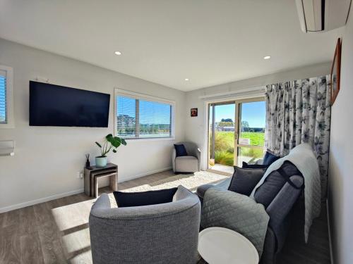 a living room with a couch and a tv at Glenwood Cottage in Kennington