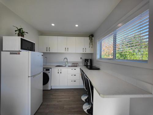 a kitchen with a white refrigerator and a window at Glenwood Cottage in Kennington