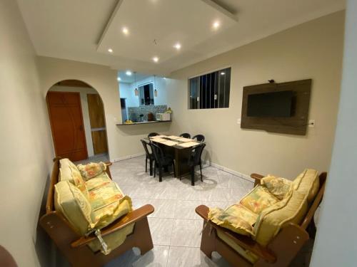 Una sala de estar con dos sillas y una mesa. en Casa e Suite Canaa, en Aparecida